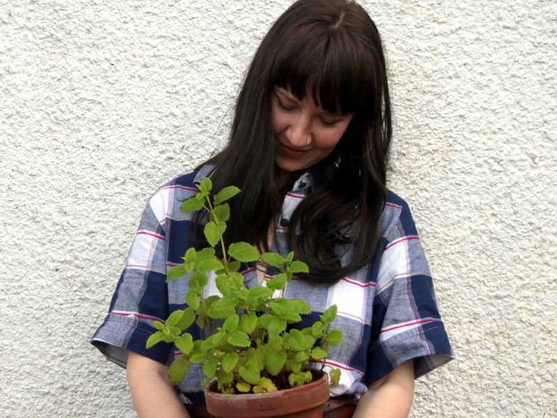 woman holding potted plant