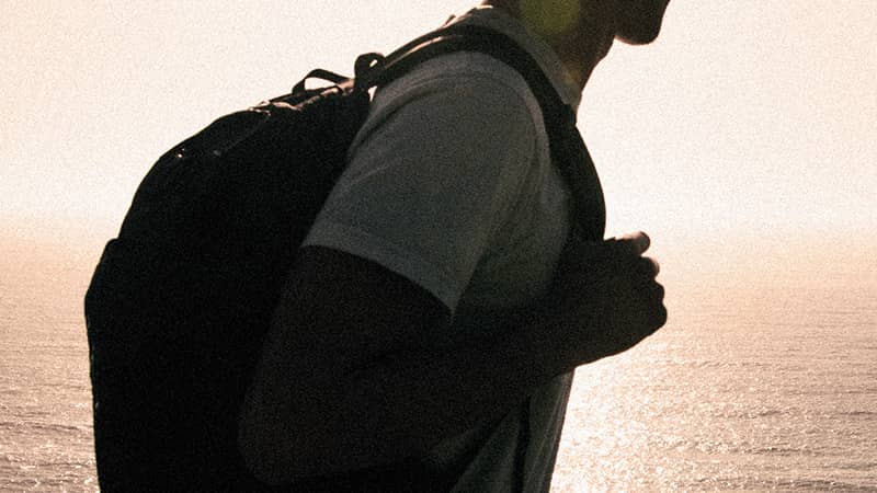 surfer wearing t-shirt and backpack