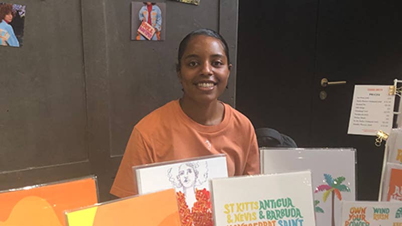 Image of Tihara Smith at an indoor craft market table with products on the table