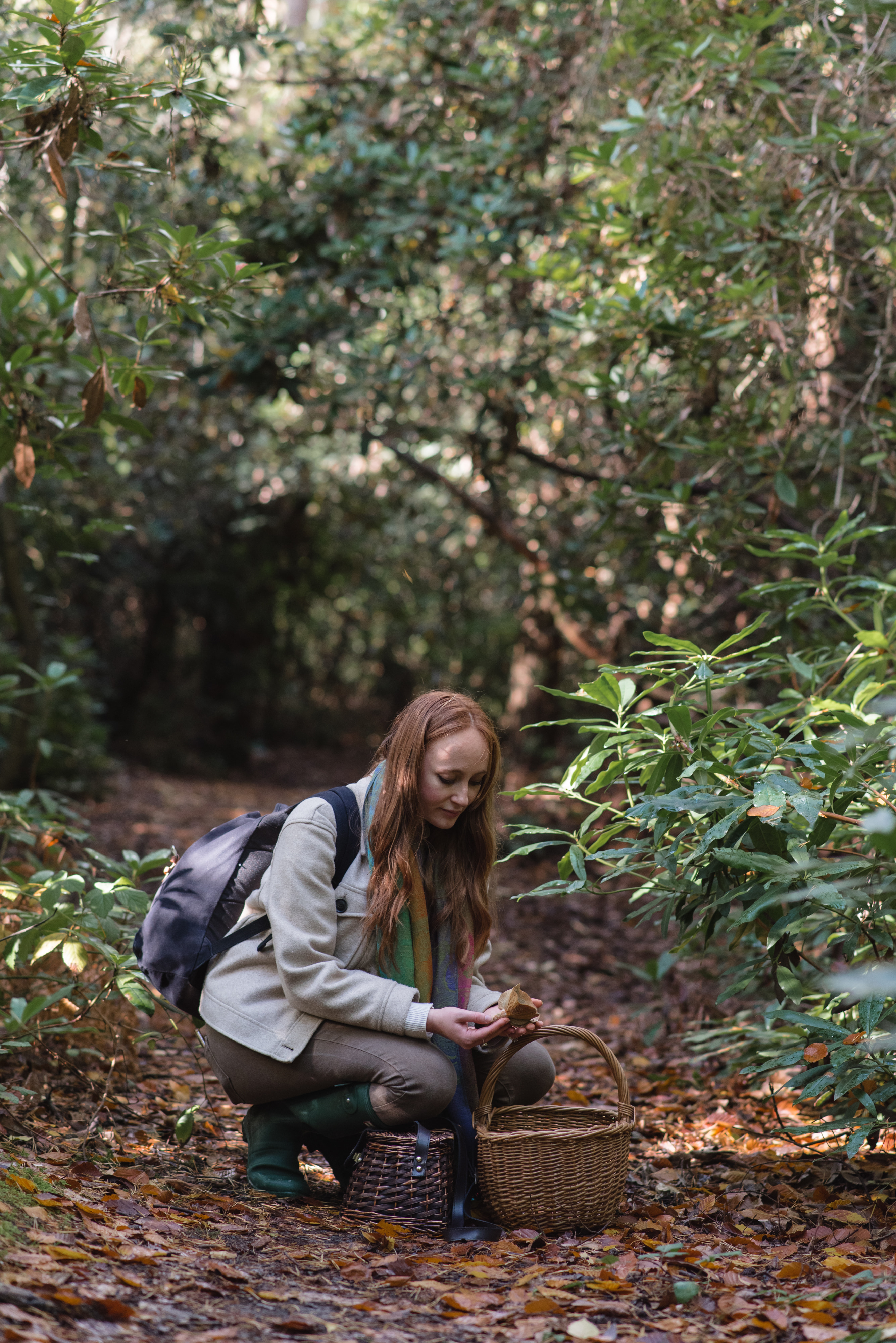 A woman holding a mushroom in the woods