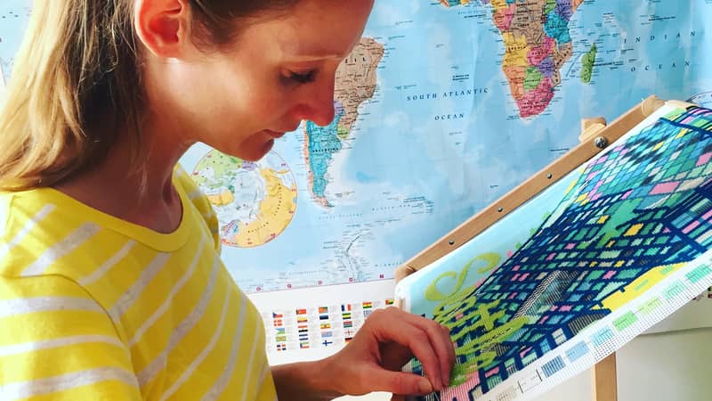 Hannah Bass needlepoint stitching a tapestry city map kit