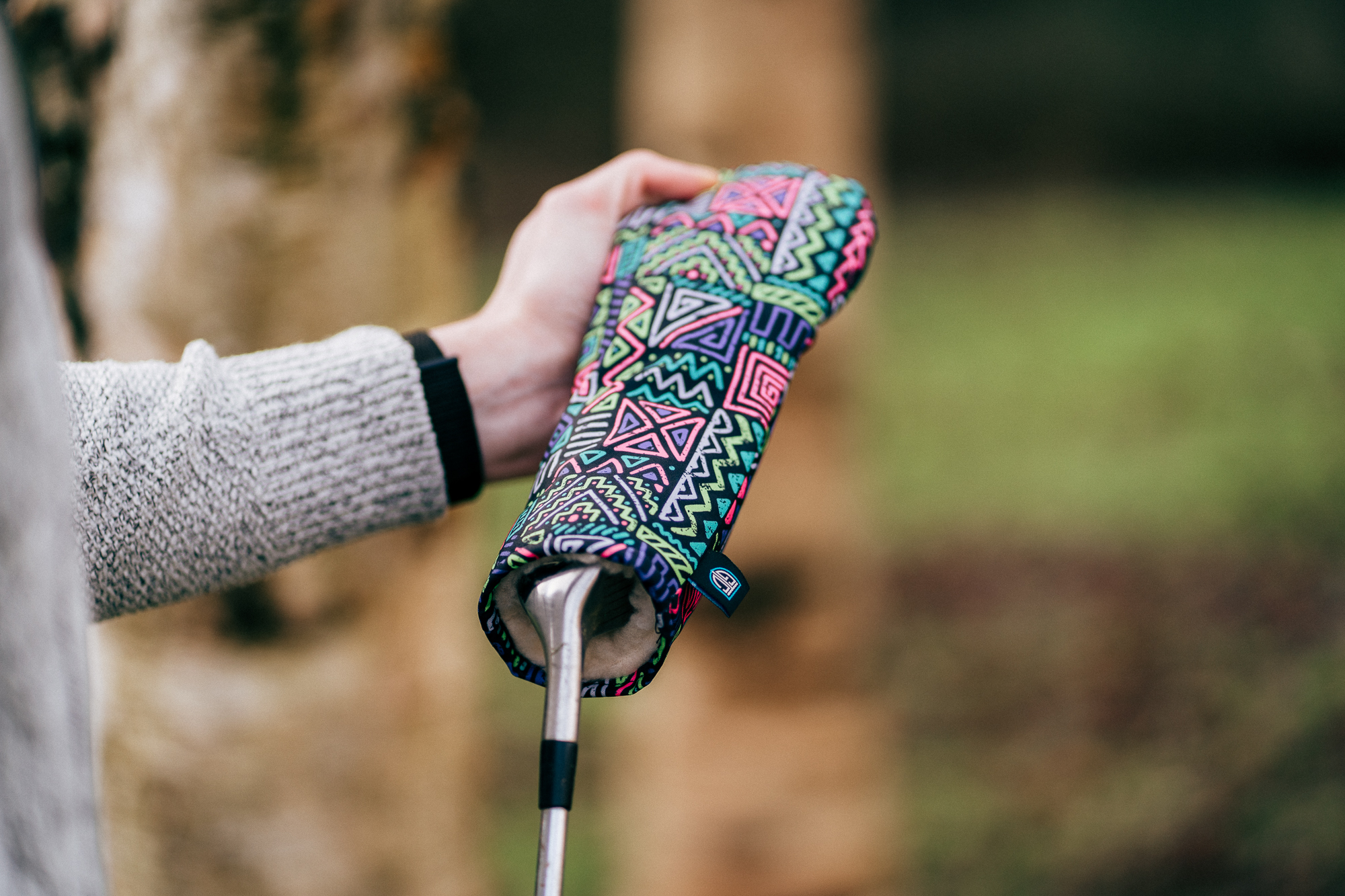 A head cover being removed from a club.