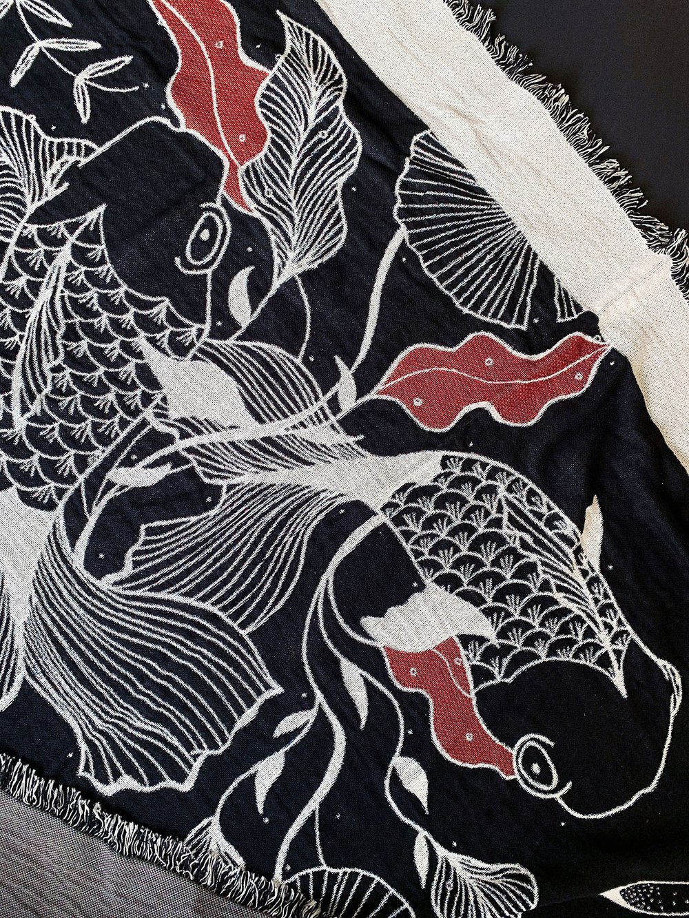 Black and white woven throw with Japanese inspired illustrative fish design