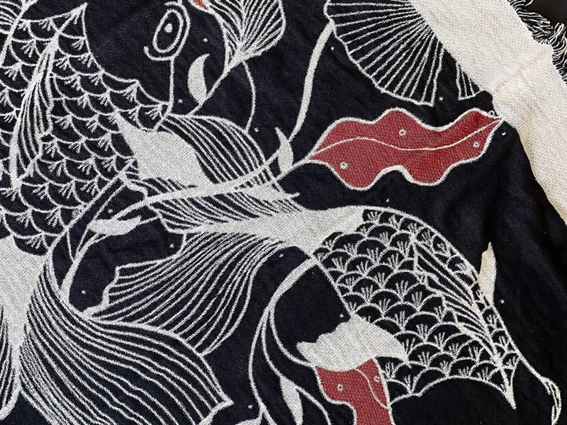 Black and white woven throw with Japanese inspired illustrative fish design