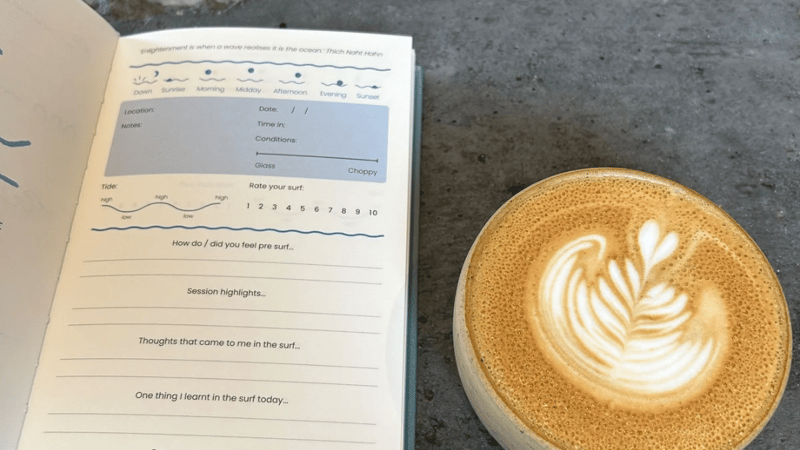 saltwater path surf journal next to a latte in a coffee shop