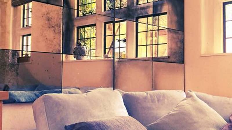 This is an antique foxed mirror panelled bespoke piece. It was made specifically to fit the customers dimensions.