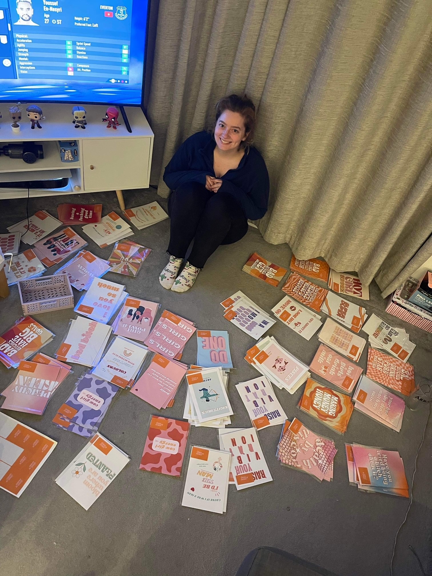 Jess surrounded by Moo & May prints smiling