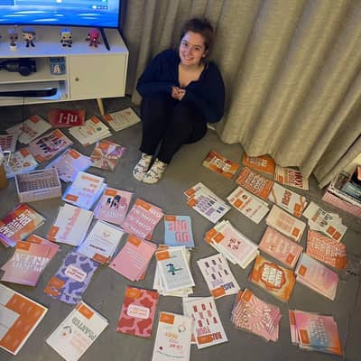 Jess surrounded by Moo & May prints smiling