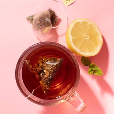 adaptogenic nootropic herbal tea blend on a pink background with lemon
