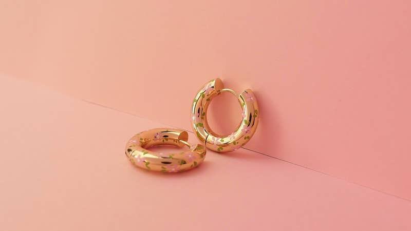 Chunky gold hoop earrings in an ear