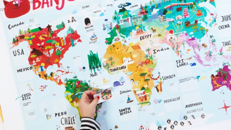 Child adding sticker to Banjo's big, beautiful world map.