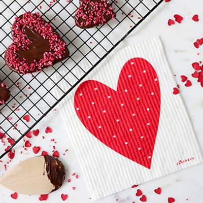 Dishcloth, screen printed with a heart design on a marble kitchen surface.