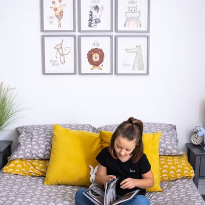 Child reading on bed in front of safari prints