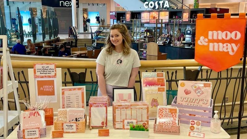 Jess standing with a Moo & May stall