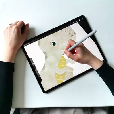 Amy illustrating a dinosaur for a new collection