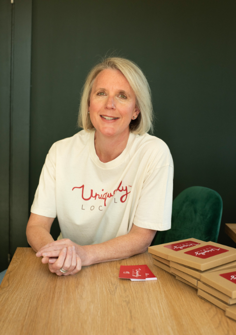 Business owner, Rachel Marshall, sat at table with voucher gift boxes