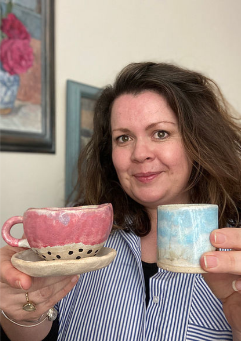 Maker with a teacup and espresso cup in hand