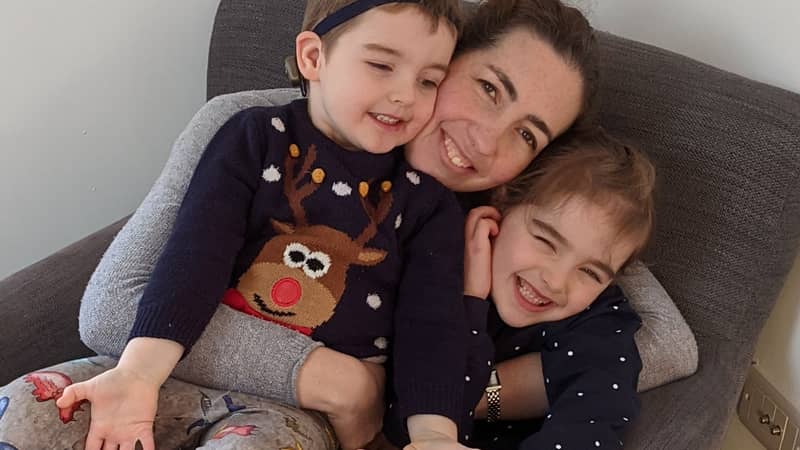 Lauren, owner, cuddling her two smiling children