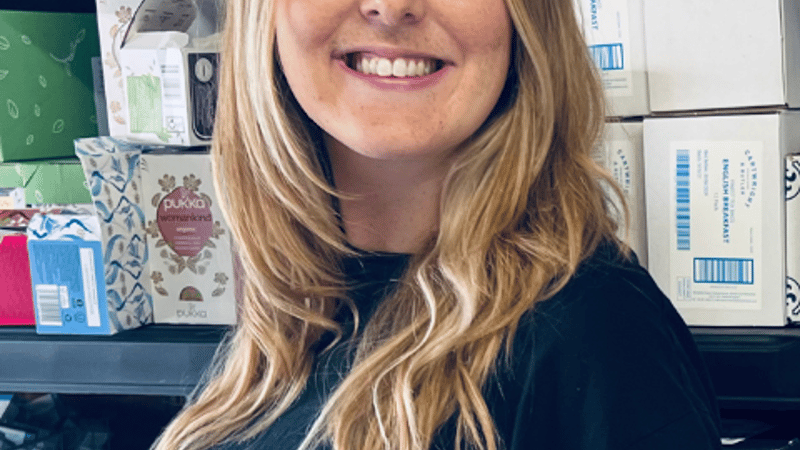 person smiling at camera in gifting warehouse