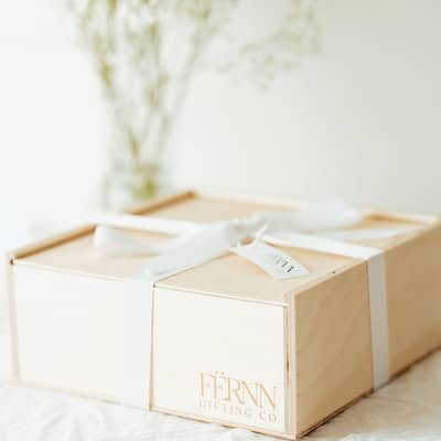 A neutral dried flower bouquet being tied with jute string by a woman's hands with white nail polish