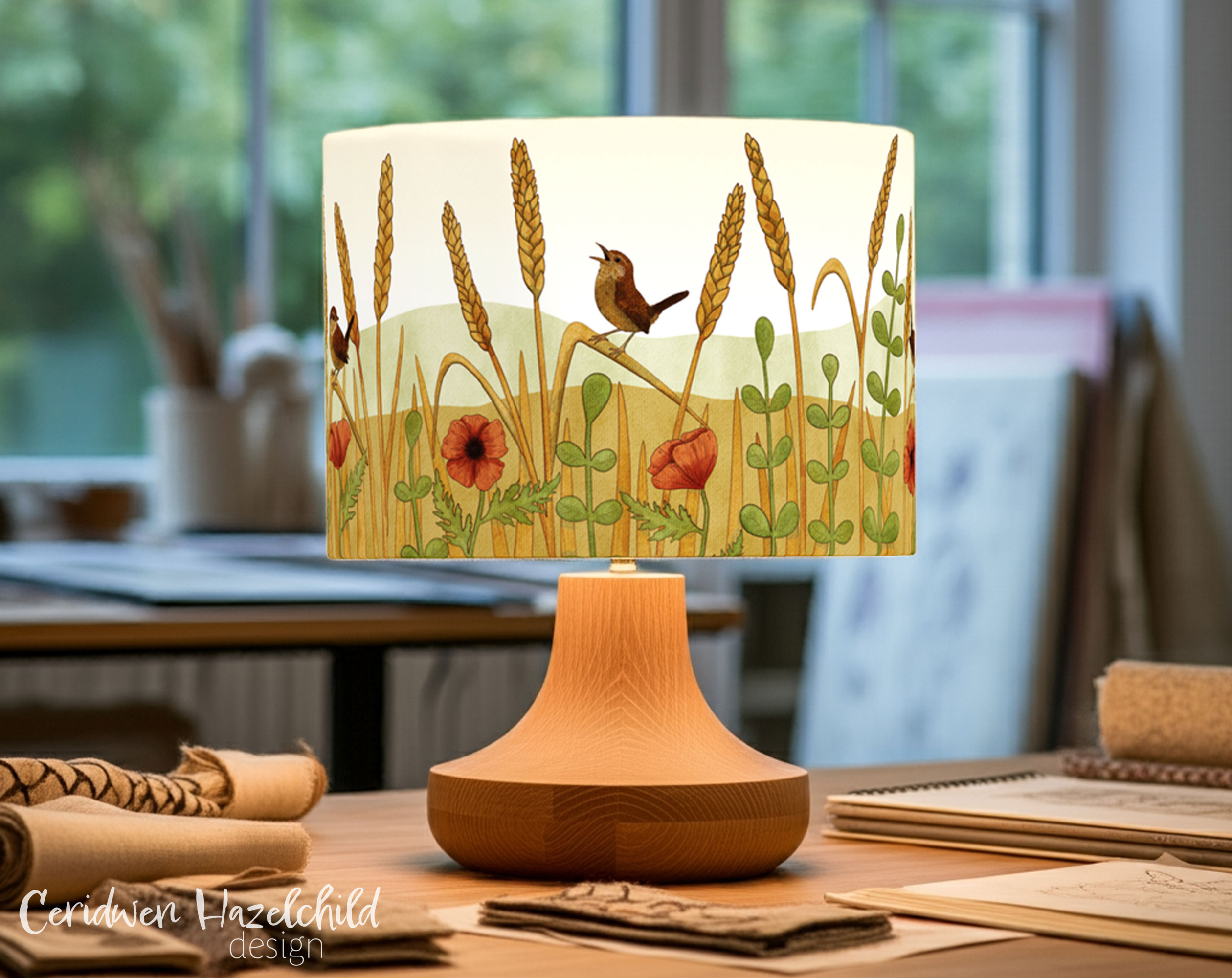 Freshly made wren lampshade by Ceridwen Hazelchild, featuring British woodland bird illustration, in a softly lit art studio.