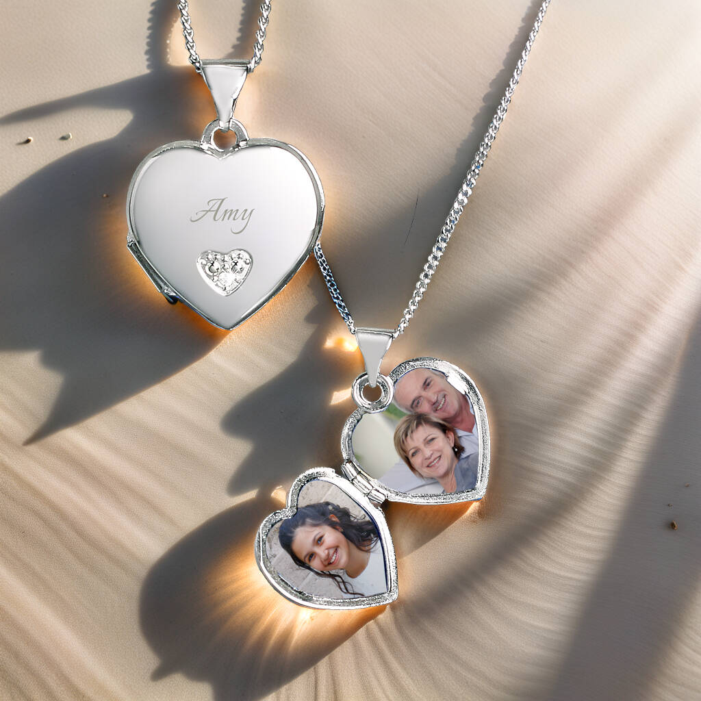 Sterling silver heart locket necklace personalised with photos and name, displayed on soft sand.