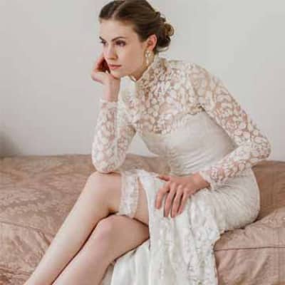 A bride sits on a couch exposing her garter