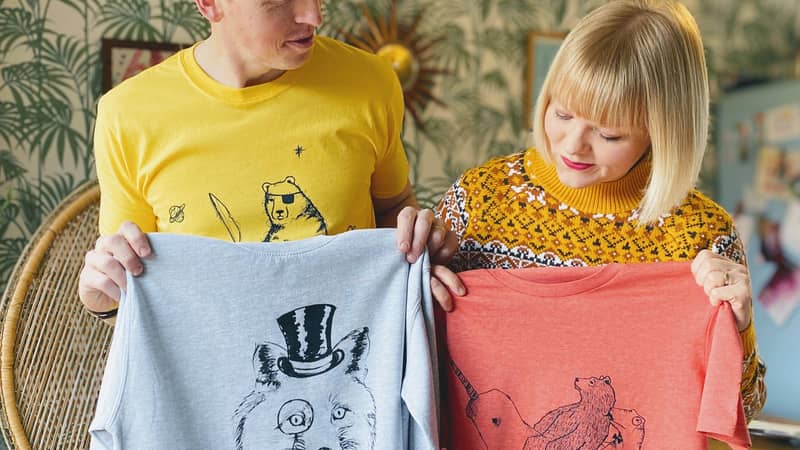 Lucy and Tom holding tshirts