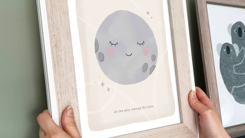 Moon print in a frame being placed on a shelf