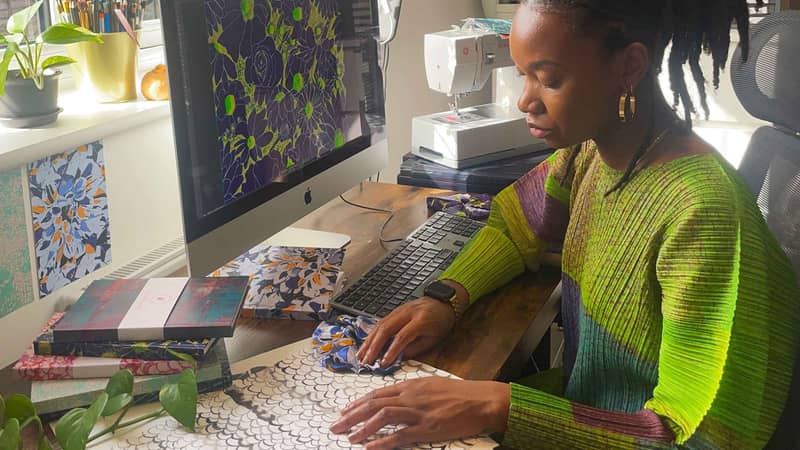 Owner of OlaOla, Ola Olayinka cutting fabric