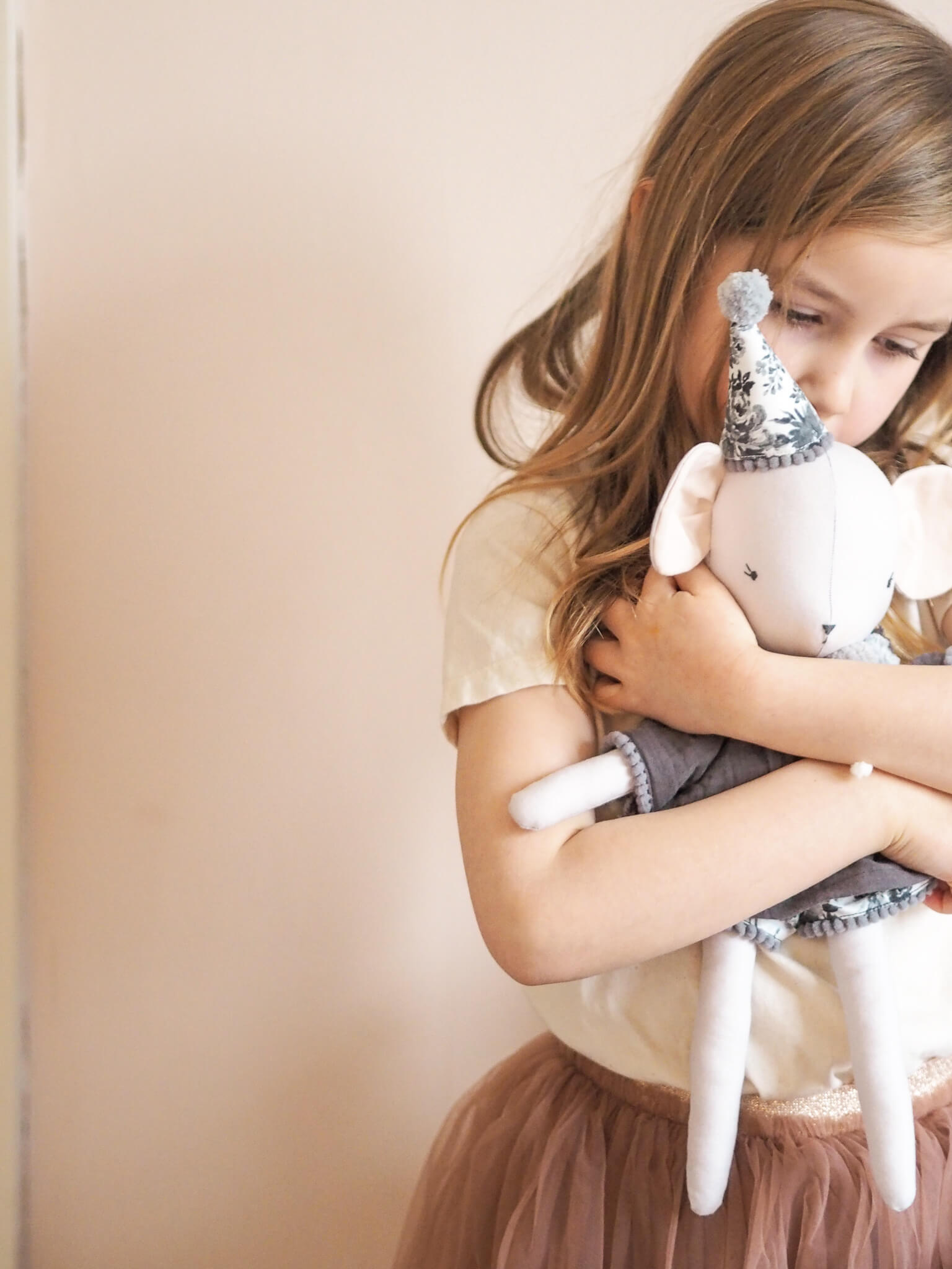 child cuddling handmade soft toy