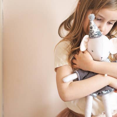 child cuddling handmade soft toy