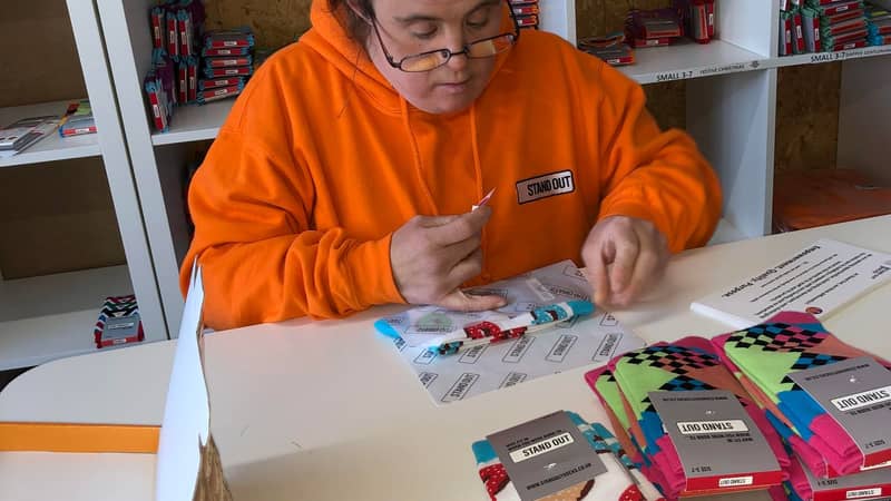 Stand Out Socks team member working hard to personally packing orders.