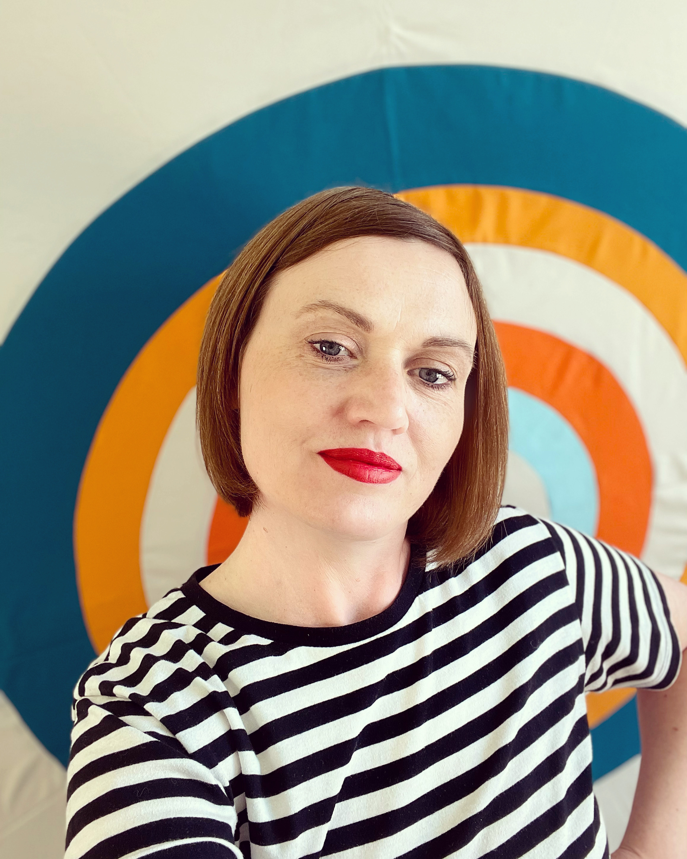 Lucy Engels standing in front of a quilt 