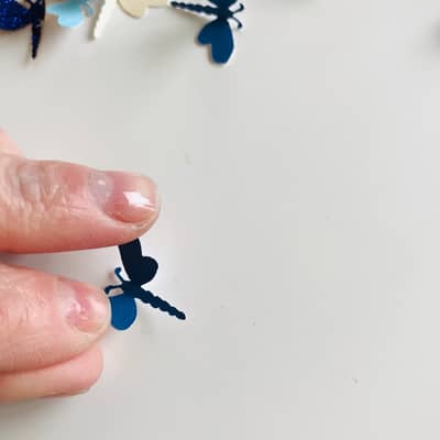 Erika pressing the dragonfly wings out so they open equally on both sides