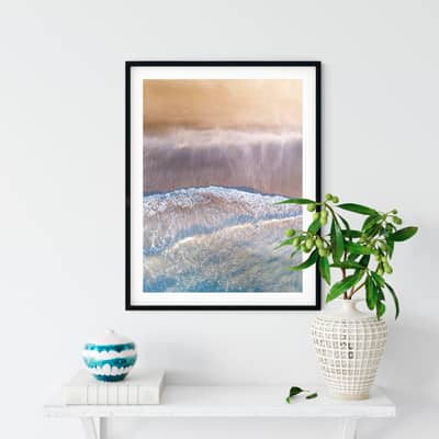Aerial photography print displayed in a frame on a shelf with a plant