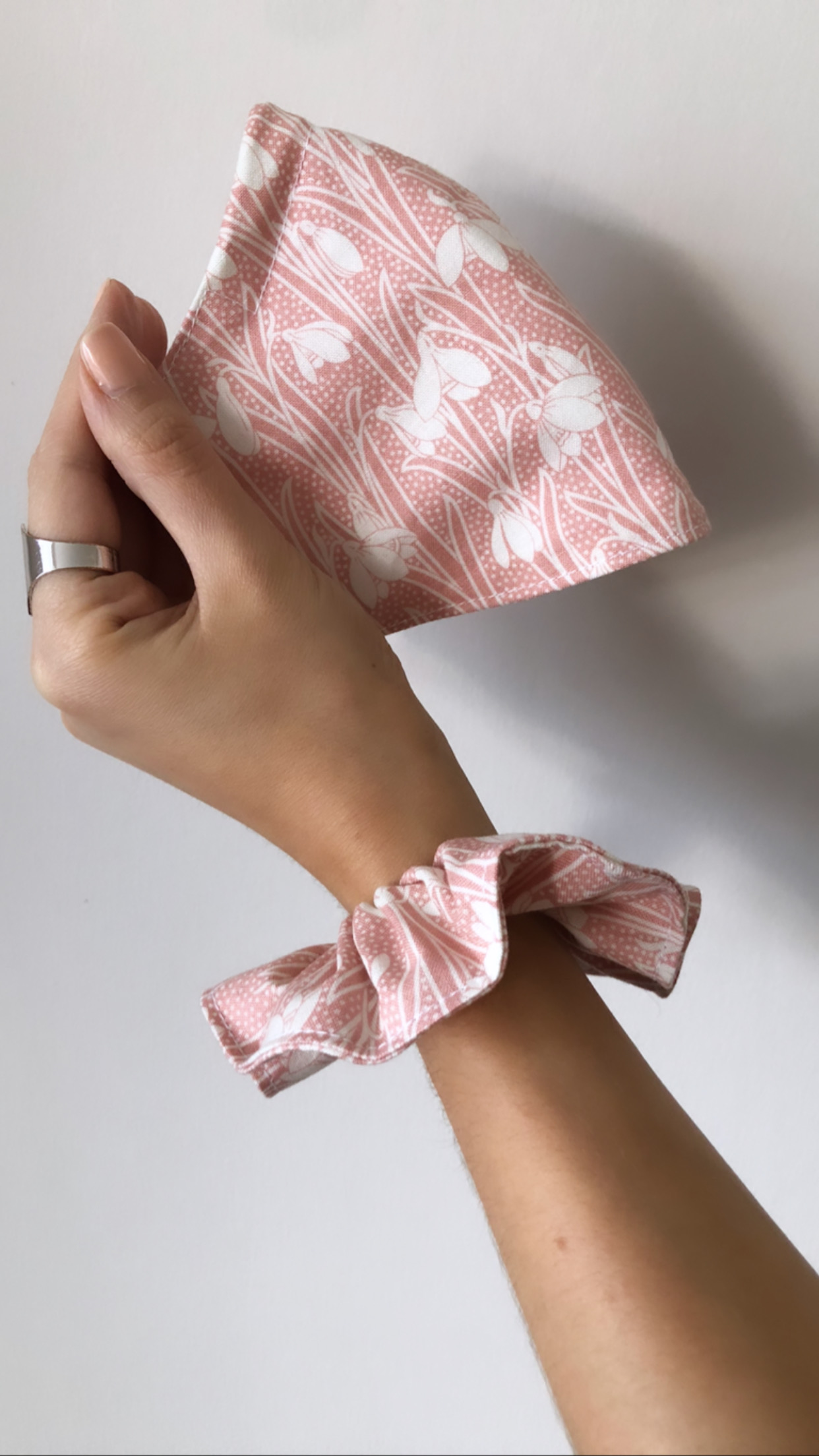Hand holding Liberty cotton face mask and matching scrunchie