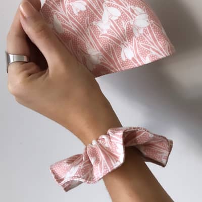 Hand holding Liberty cotton face mask and matching scrunchie