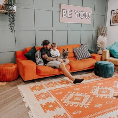 A southwestern orange rug with aztec diamond pattern in a large lounge