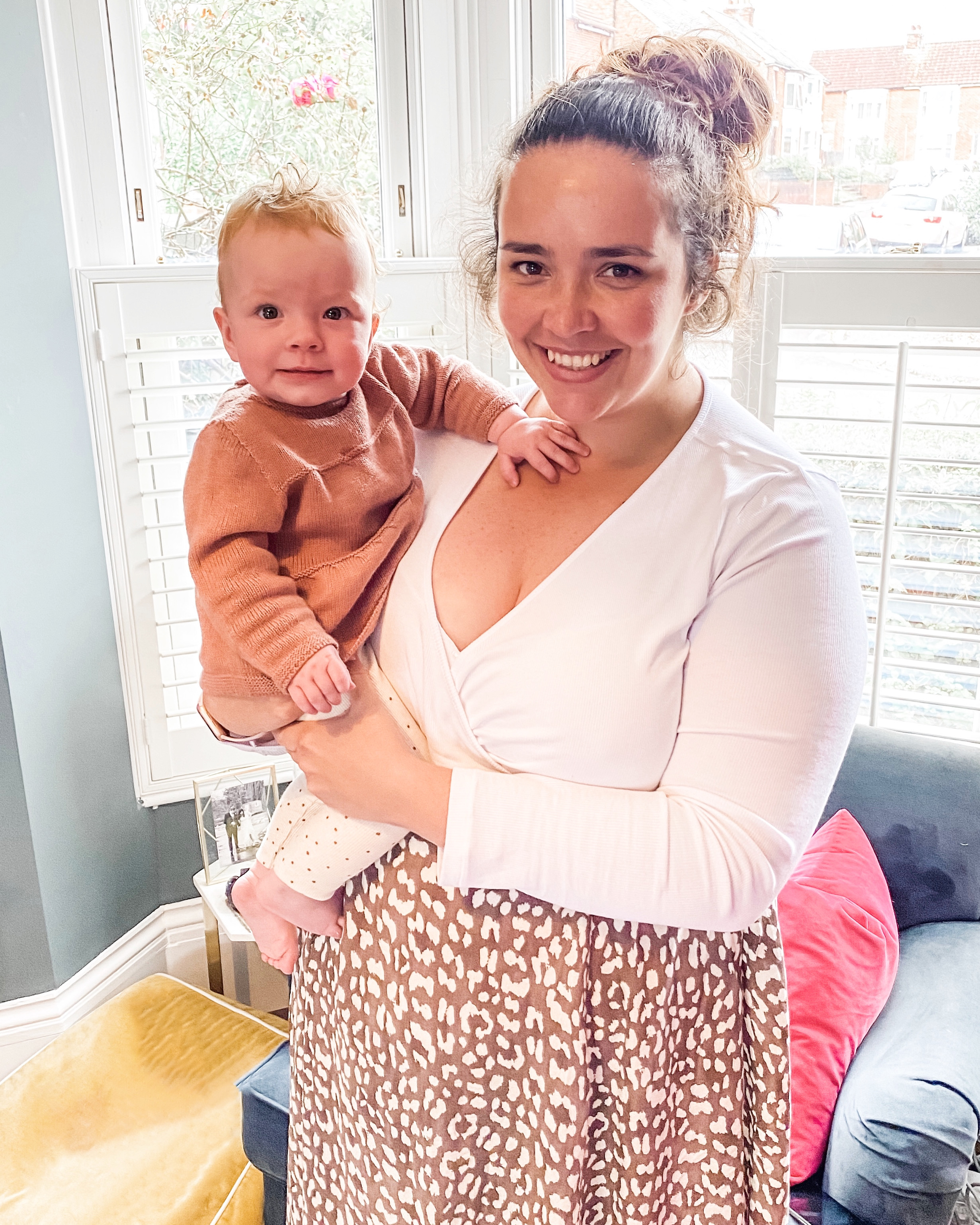 Mother holding a baby standing in a window