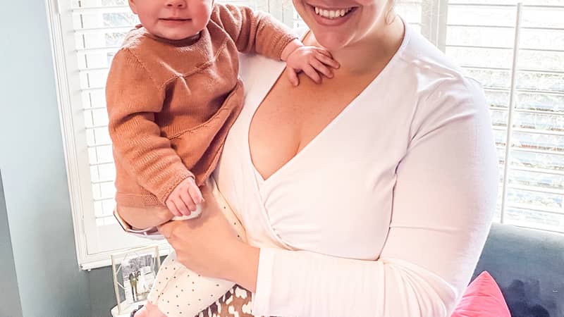Mother holding a baby standing in a window