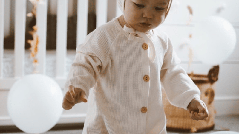 baby in cream waffle romper set with bonnet