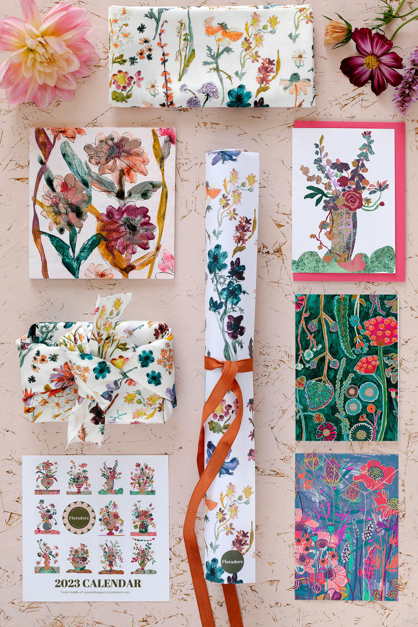 A Floradore product flatlay featuring wrapping paper, 2023 calendar, furoshiki wraps and postcards.