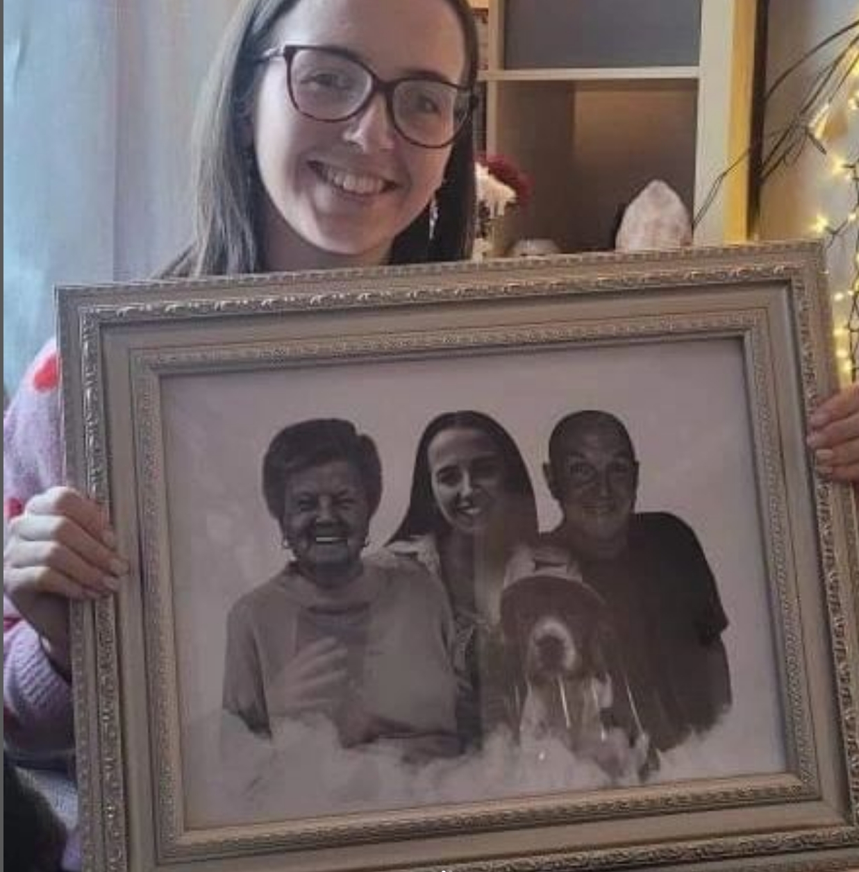 Smiling customer holding a framed blended photo merge of family members