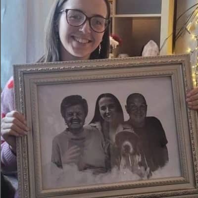 Smiling customer holding a framed blended photo merge of family members