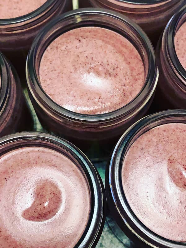 Pots of freshly made beetroot face polish in clear glass jars