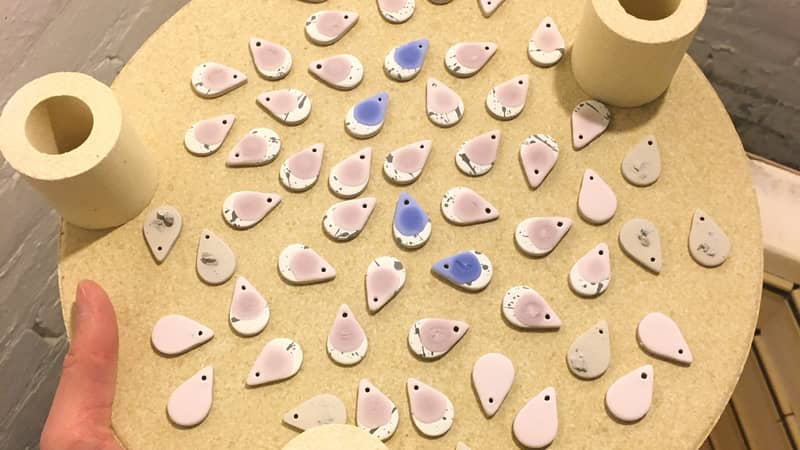 Behind the scenes making ceramic earrings earrings on a kiln shelf