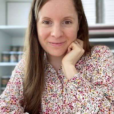 Laura Clempson, the owner of 34th Street is sitting in the studio wearing a floral blouse.