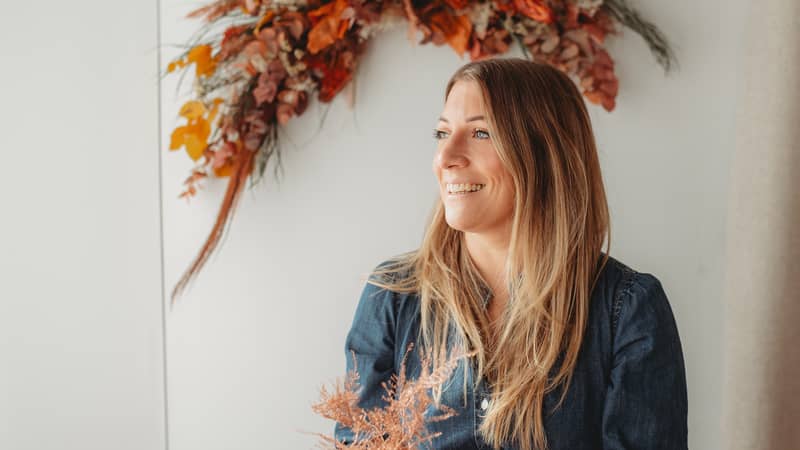 Chloe, founder of Sown and Wild surrounded by her flowers.