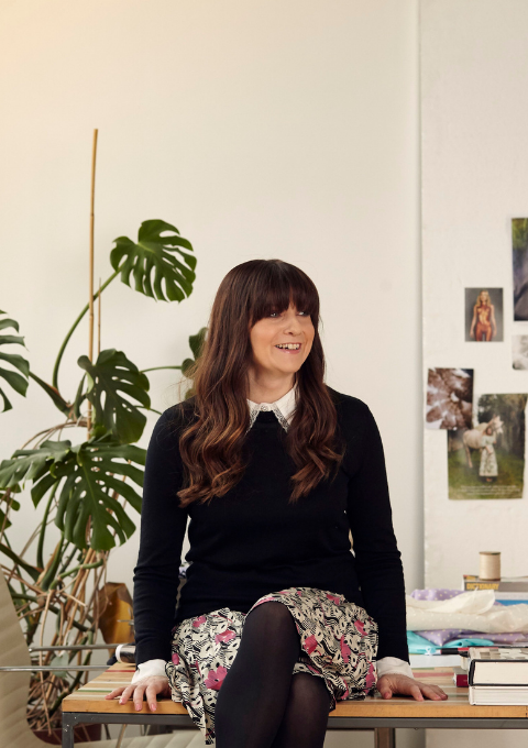 Our founder Paula sitting on a desk